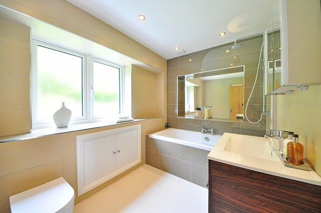 Modern Bathroom With White Tub, Large Mirror, Double Window, And Wood Vanity