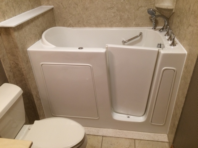 Walk-In Bathtub With Door And Safety Grab Bar Installed In Compact Bathroom